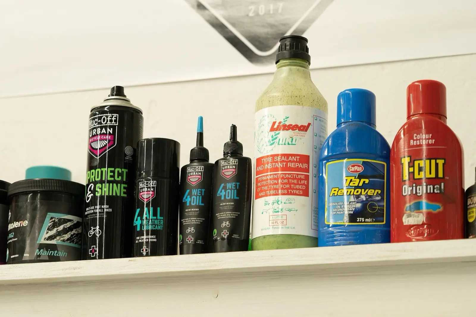 Bottles of bike oil, grease and tyre sealant on a shelf